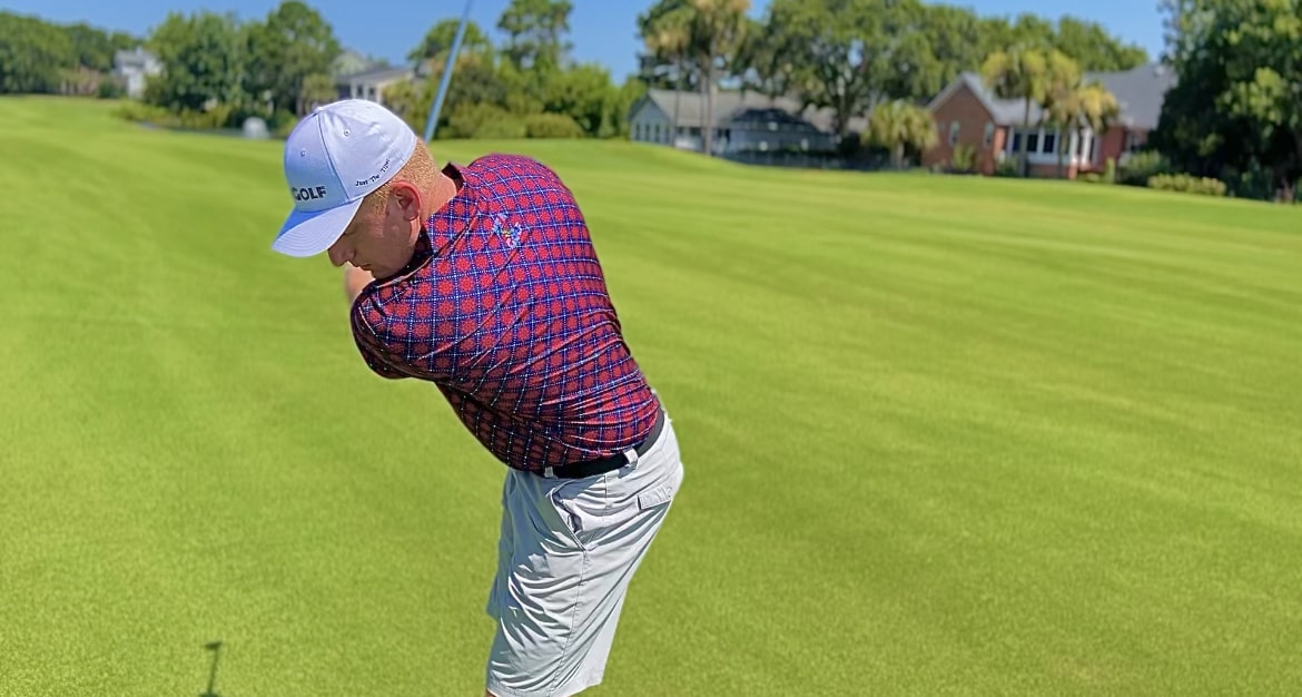 customer wearing the "red, white, and bunker" golf shirt by KEA Golf on the golf course